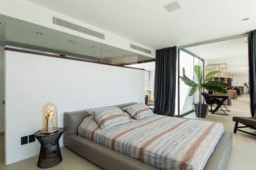 Double bedroom separated through a glass wall from living room