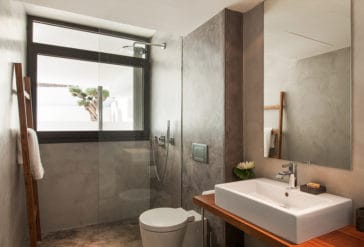 Modern bathroom with square one sink vanity, toilet and walk-in shower with grey walls