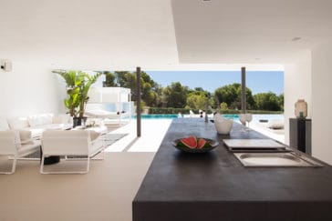 Covered outdoor kitchen with seating group in front of pool