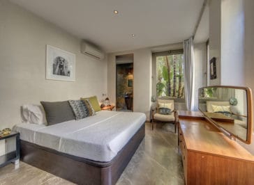 Double bedroom with en-suite bathroom, a window and commode with mirror in front of the bed