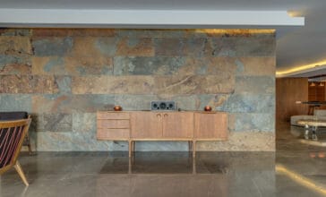 Modern wooden mid century style design commode in front of marble wall