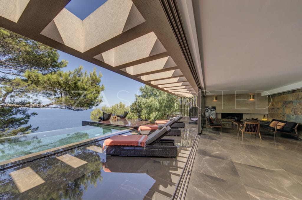 Glass fronted living room open to adjacent infinity pool terrace