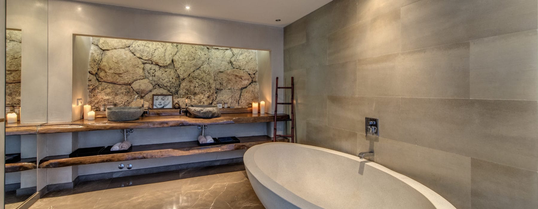 Bathroom with stone design wall and oval bathtub
