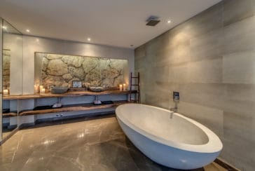 Bathroom with stone design wall and oval bathtub