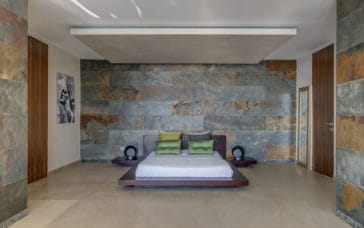Bedroom with low square bed and marble designed walls