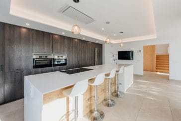 Modern kitchen with dark wooden cupboard wall and white kitchen centre