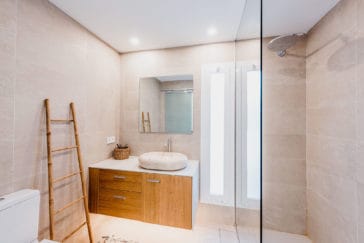 En-suite bathroom with walk-in shower in light stone colours and wooden washbasin cabinet