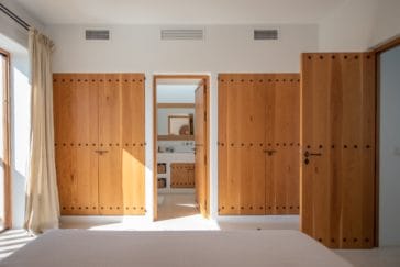 Bedroom's bathroom access between wooden closet walls