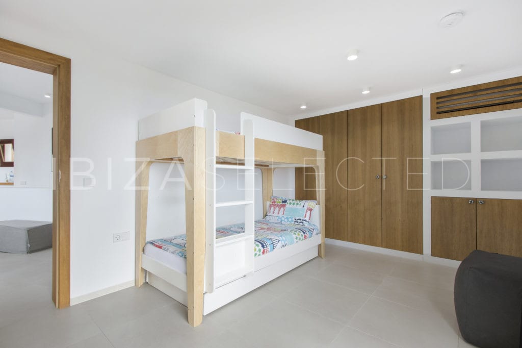Room with children's loft bed and wooden wardrobe