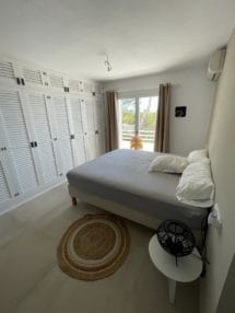 Bedroom with large with wooden clothes wardrobe and door window