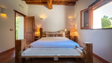 Rustic double bedroom with wooden beam roof and wooden furniture