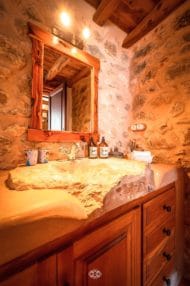 Rustic bathroom with stone walls and sink made of one piece of stone
