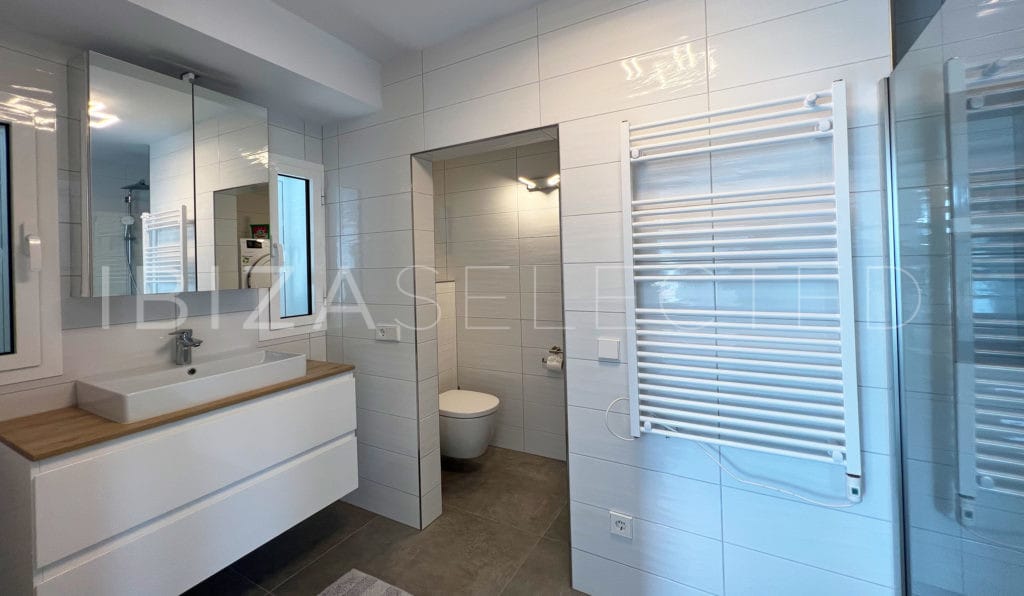 Bathroom with separate toilet, one sink vanity and towel heater