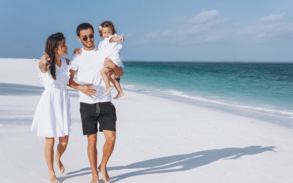 Young Family With Little Daugher On A Vacation By The Ocean